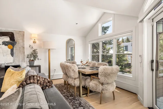 a dining room with furniture a rug and a large window