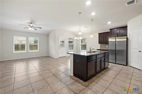 a kitchen with stainless steel appliances granite countertop a refrigerator and a sink