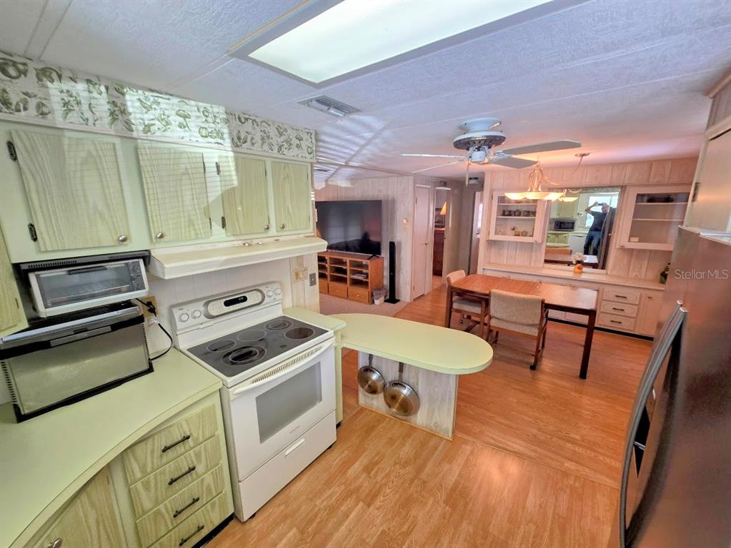 12501 Ulmerton Road, Unit 188 Largo, FL 33774 - Photo 9 of 63 a kitchen that has a stove a table and chairs in it