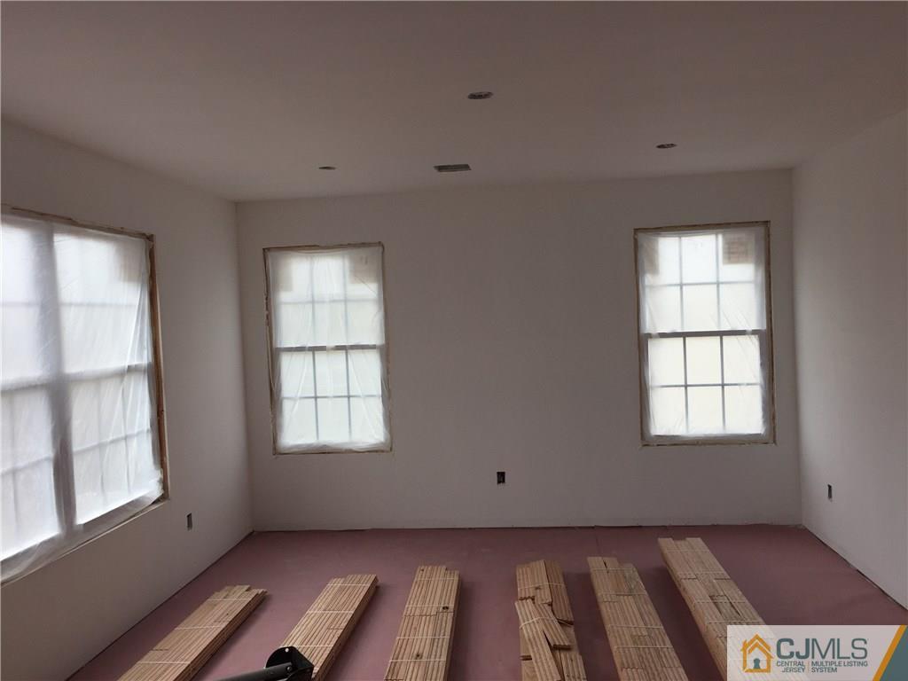 162 Larch Street Port Reading, NJ 07064 - Photo 5 of 9 an empty room with wooden floor and windows