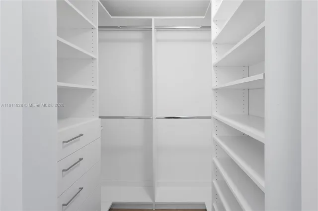 a view of walk in closet with empty racks