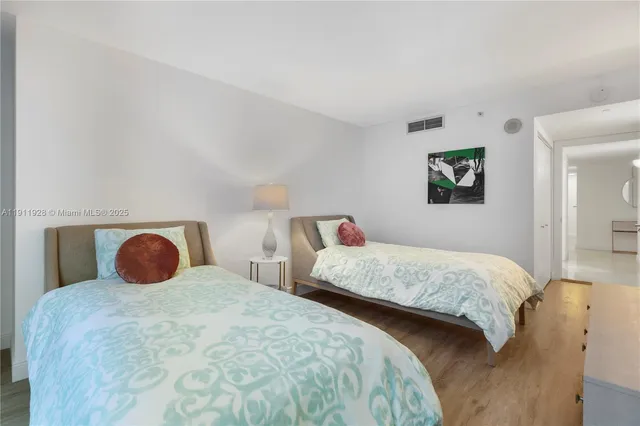 a bedroom with two beds and painting on the wall