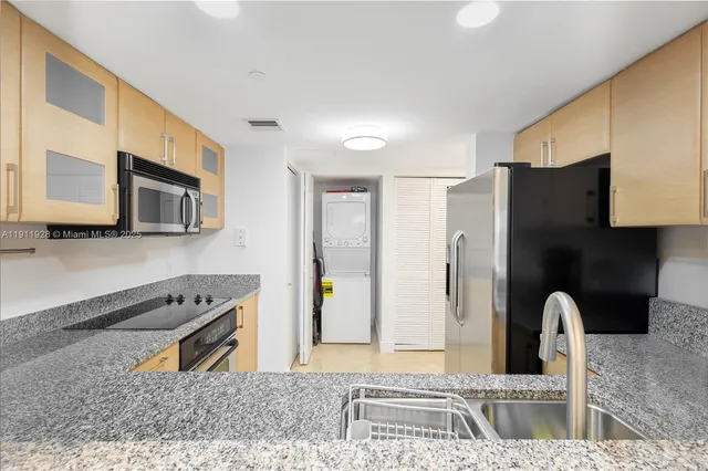 a kitchen with stainless steel appliances granite countertop a refrigerator and a stove top oven
