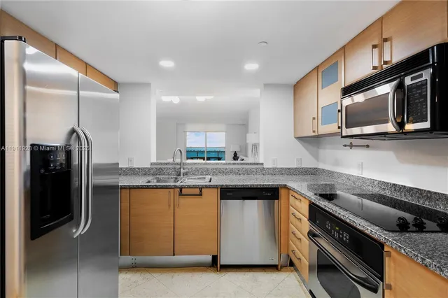 a kitchen with stainless steel appliances granite countertop a stove a sink and a microwave