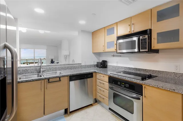 a kitchen with stainless steel appliances granite countertop a stove microwave and sink