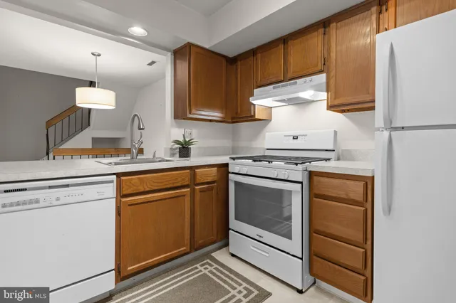 a kitchen with white cabinets and white appliances