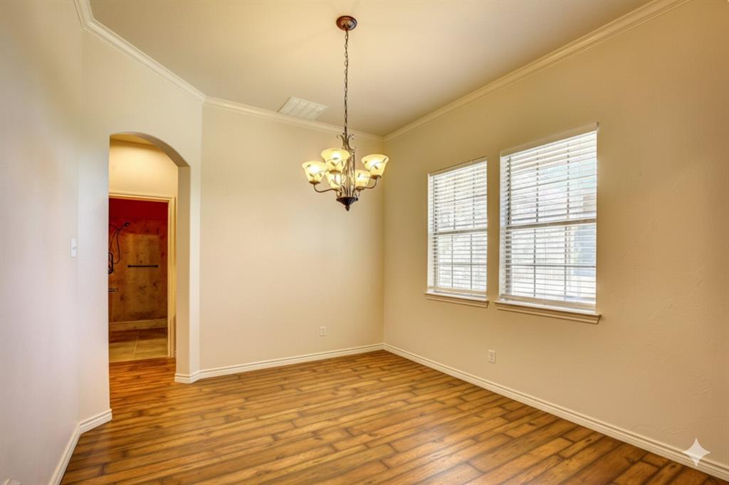 2617 Kirby Road Rowlett, TX 75088 - Photo 15 of 39 Unfurnished room with a chandelier, ornamental molding, arched walkways, and wood-type flooring