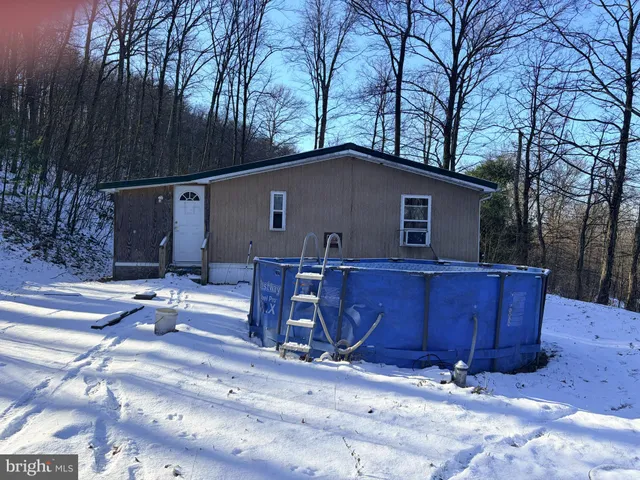 a backyard of a house with barbeque oven and wooden fence