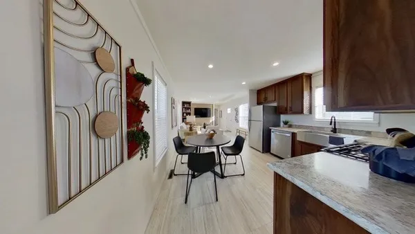 a kitchen with a table chairs refrigerator and cabinets
