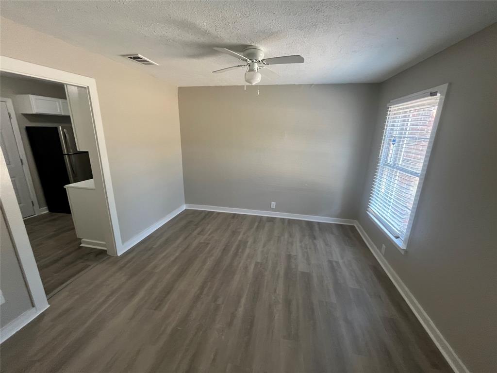 1622 Centerville Road Dallas, TX 75228 - Photo 6 of 19 Wood-finish flooring, neutral wall tones, window with horizontal blinds, and a ceiling fan with integrated lighting