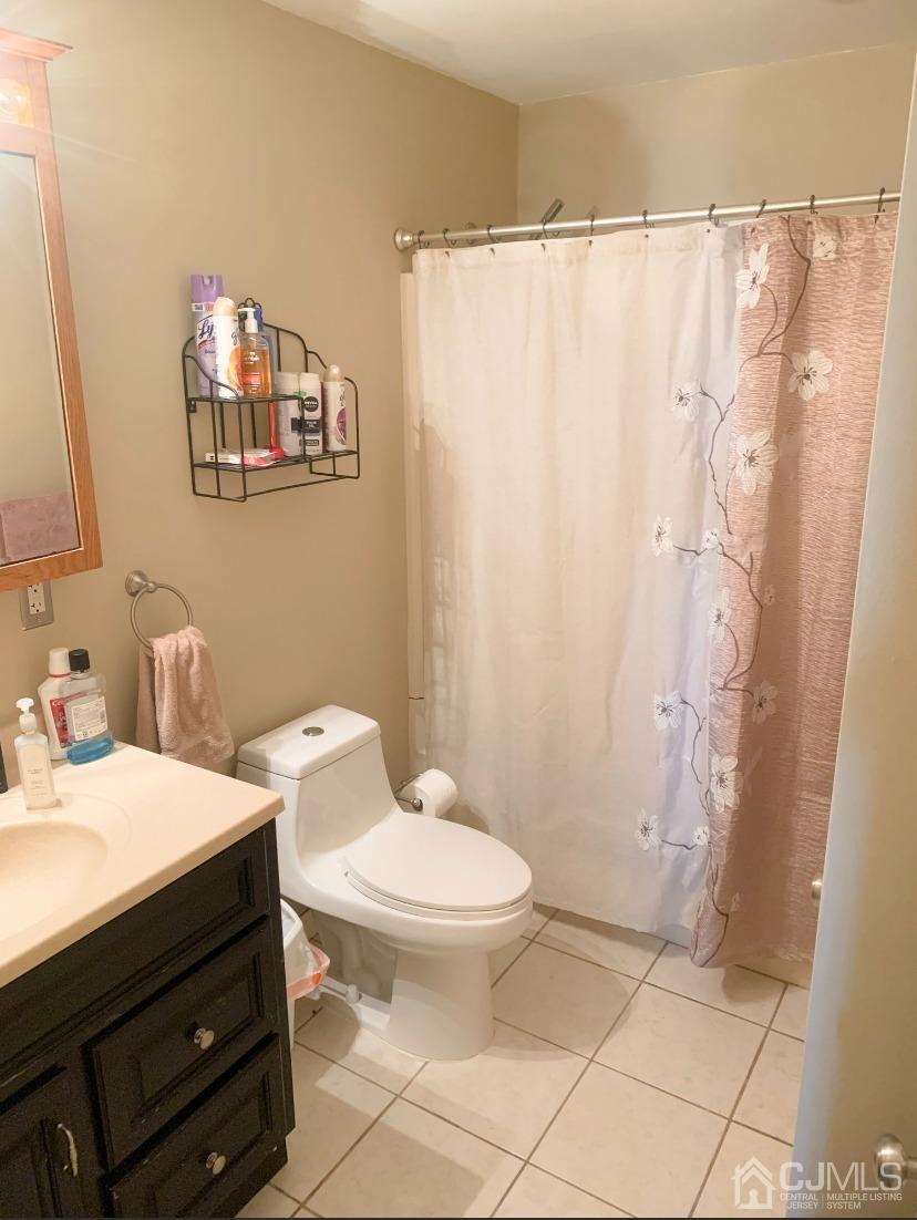 91 Ashley Road Edison, NJ 08817 - Photo 8 of 14 a bathroom with a sink a toilet and shower curtain