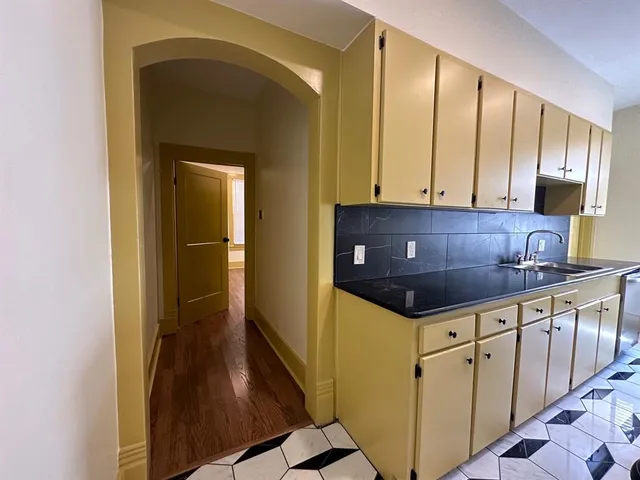 a kitchen with granite countertop a sink and cabinets