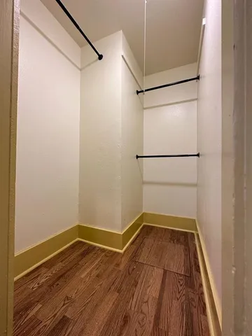 a view of a room with wooden floor and white walls