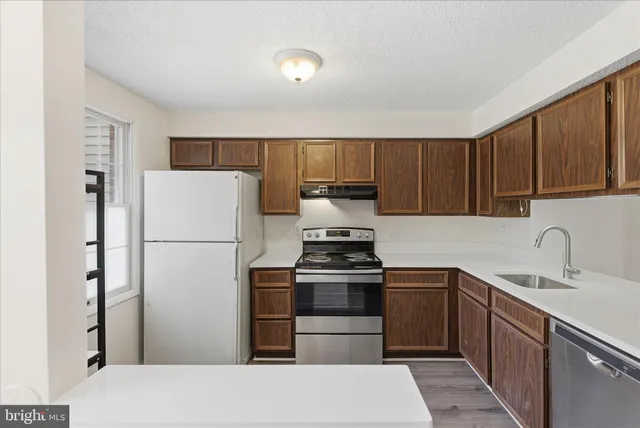 a kitchen with a refrigerator sink and cabinets