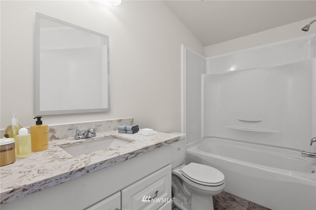 18512 Elderberry Street Southwest Rochester, WA 98579 - Photo 17 of 18 a bathroom with a granite countertop sink a toilet and a bathtub