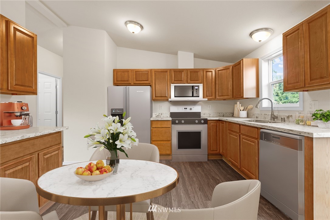 18512 Elderberry Street Southwest Rochester, WA 98579 - Photo 6 of 18 a kitchen with stainless steel appliances a dining table and chairs
