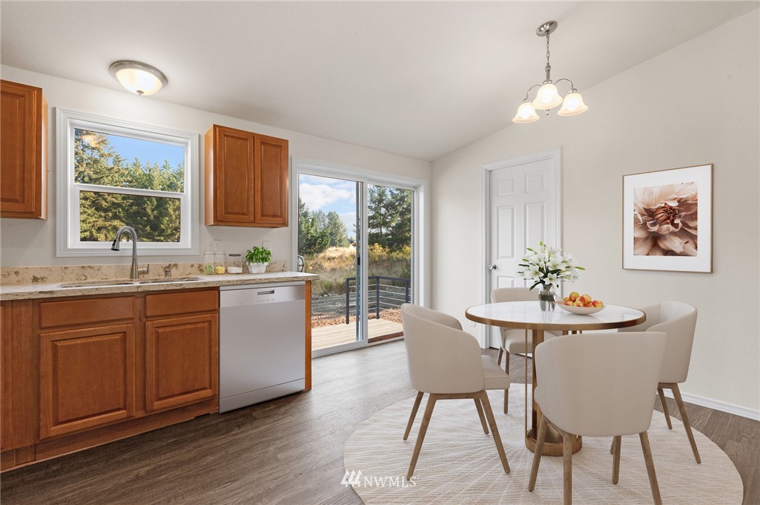 18512 Elderberry Street Southwest Rochester, WA 98579 - Photo 8 of 18 a kitchen with stainless steel appliances granite countertop a dining table chairs and a large window