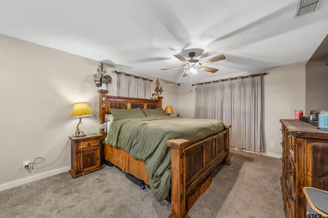 a spacious bedroom with a bed and a chandelier