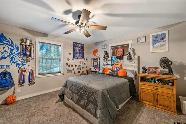 a bedroom with a bed and a flat tv screen on the dresser