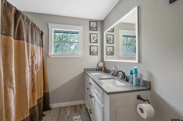 a bathroom with a granite countertop sink a mirror and a window