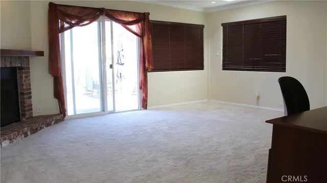 a view of a livingroom with a large window and wooden floor