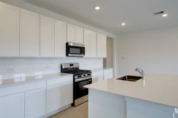 a kitchen with white cabinets and stainless steel appliances