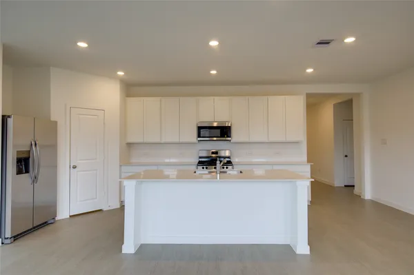 a kitchen with kitchen island a sink stainless steel appliances and cabinets