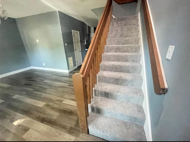 a view of staircase with white walls and railing