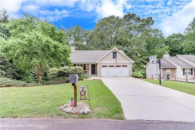a view of house with a yard and potted plants
