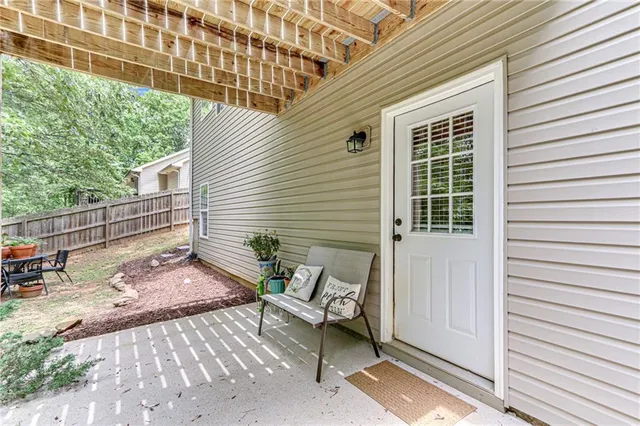 a view of backyard with a table and chairs with wooden fence and trees