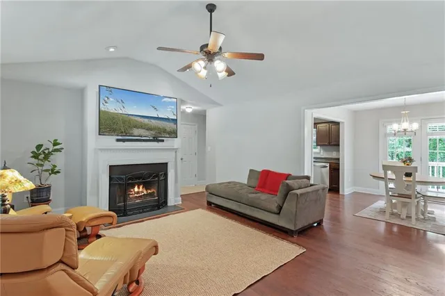 a kitchen with stainless steel appliances wooden floor dining table and chairs