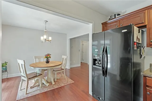 a dining room with furniture a chandelier and wooden floor