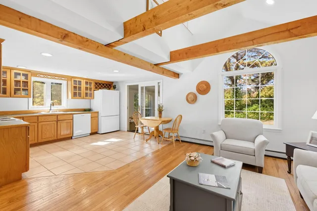 a kitchen with a dining table chairs and refrigerator
