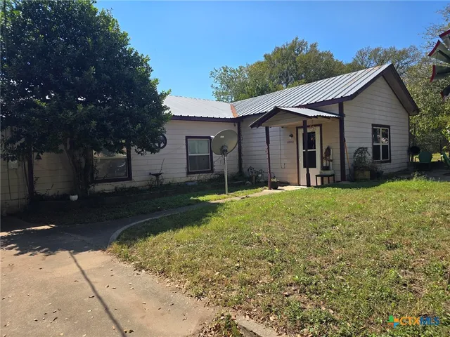 a view of a house with yard and tree s