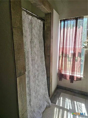 a view of a bathroom with a tub and shower