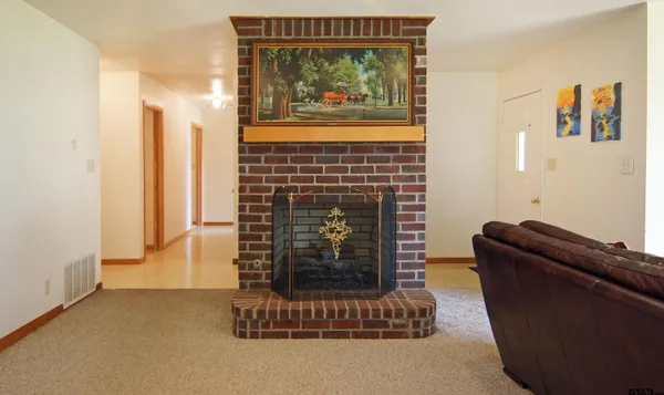 a living room with furniture a fireplace and a window