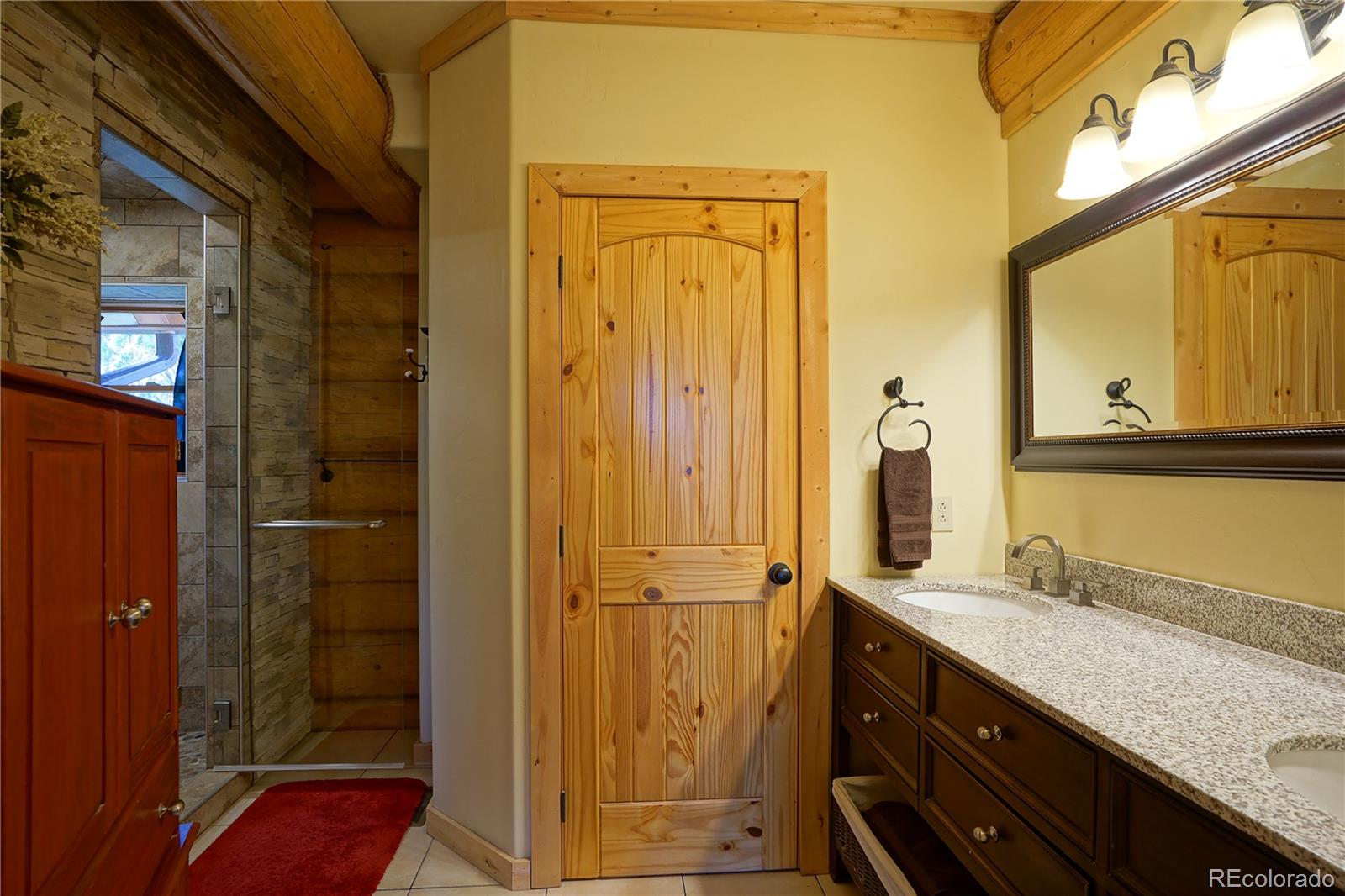 810 Mustang Road Rye, CO 81069 - Photo 24 of 50 a bathroom with a granite countertop sink and a mirror
