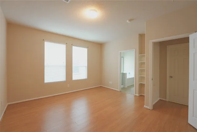 an empty room with windows and closet