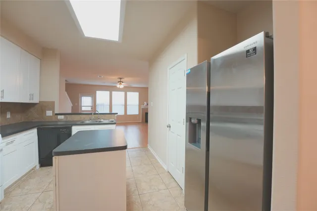 a kitchen with kitchen island a counter top space a sink and refrigerator