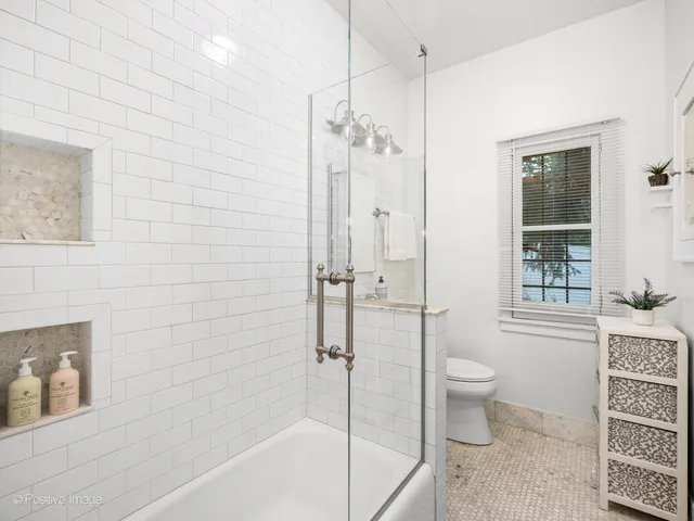 a bathroom with a granite countertop sink a toilet and shower