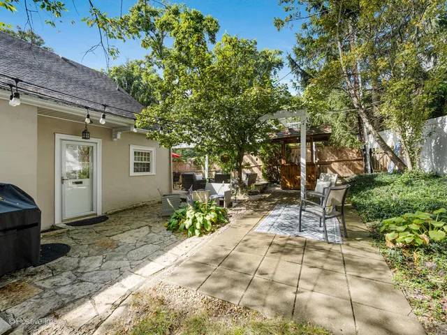 a patio with table and chairs and potted plants