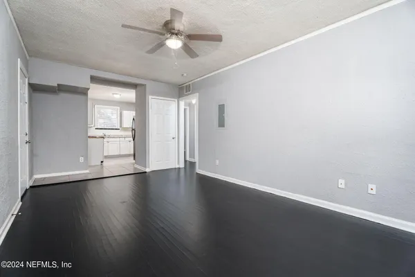 an empty room with wooden floor and windows