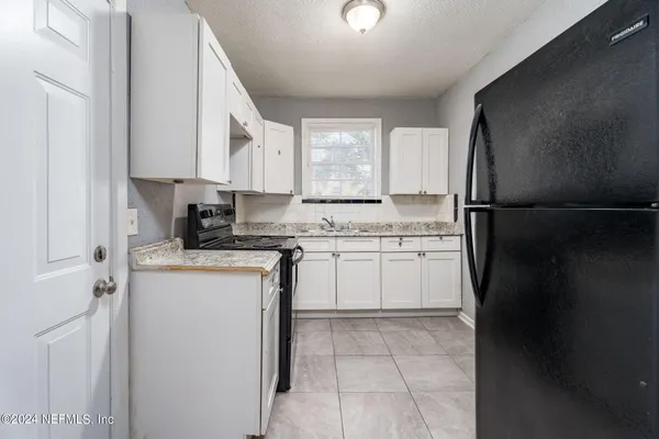 a kitchen with a refrigerator sink and cabinets