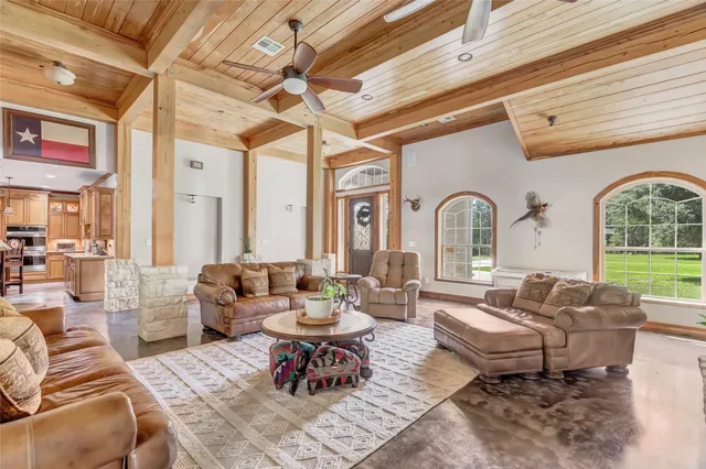 a living room with patio furniture and potted plants