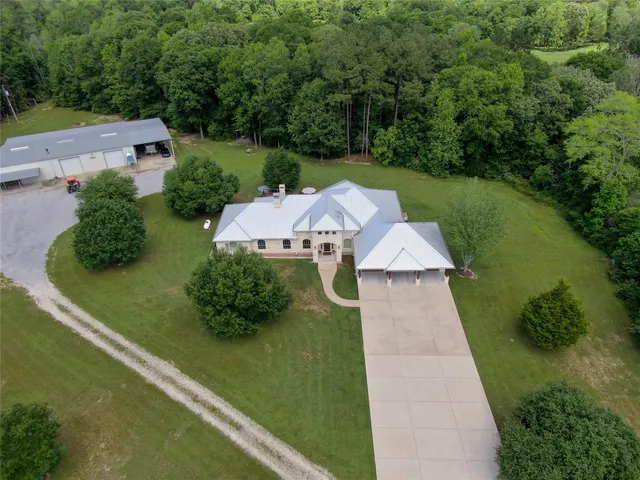 an aerial view of a residential houses with yard