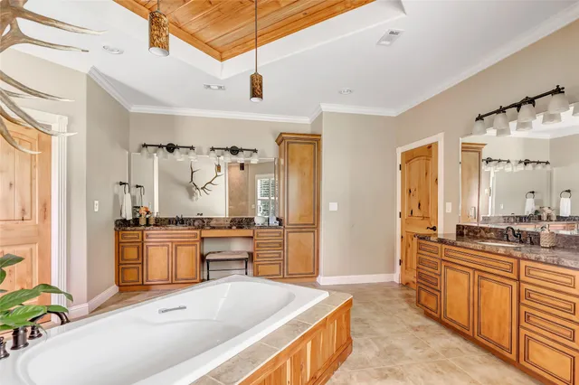 a spacious bathroom with a tub sink and mirror