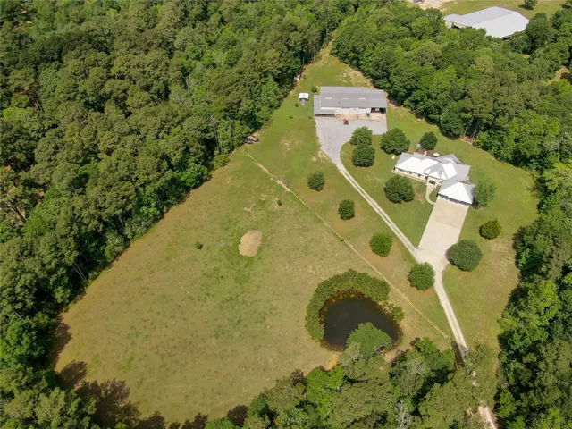 an aerial view of a residential houses with yard
