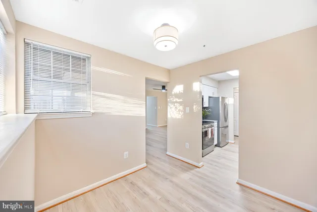 a view of empty room with wooden floor and window