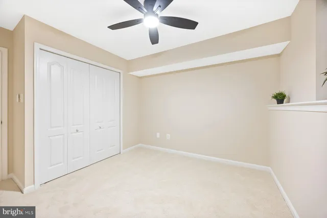 an empty room with a window and a ceiling fan