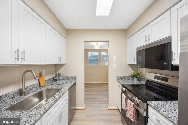 a kitchen with granite countertop a sink and a stove top oven